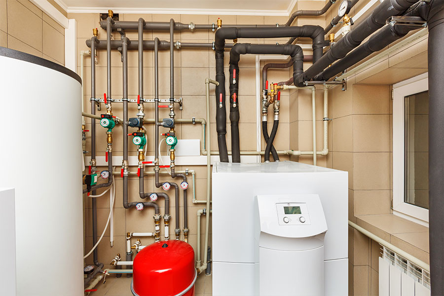 A white geothermal heat pump system in the basement of a residential home in the Metro East area.