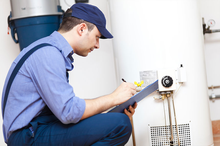 A plumber with years of experience examining a broken water heater that is taking too long to heat up in the Metro East.