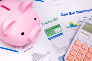 Piggy bank by gas and bill for saving money on the person's air conditioner energy cost in the summer in the Metro East area.